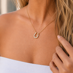 Gold horseshoe necklace with sparkling crystal pendant, delicate chain, and adjustable extender, waterproof hypoallergenic jewelry